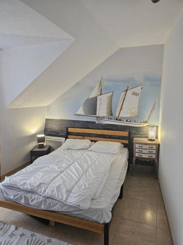 布雷阿勒Saint Martin Appartement Duplex Proximité Immédiate Mer & Commerces的卧室配有一张大床,墙上挂着帆