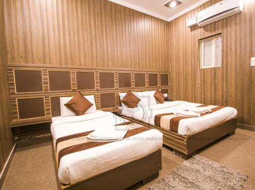 哈里瓦Hotel Paradesi and Restaurant AJ Group的一间客房内配有两张床的房间