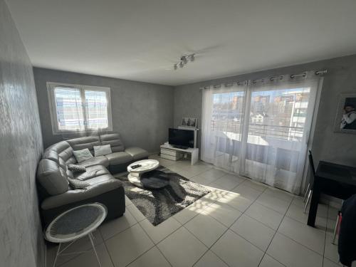 安锡Appartement de Romain的客厅配有沙发和桌子