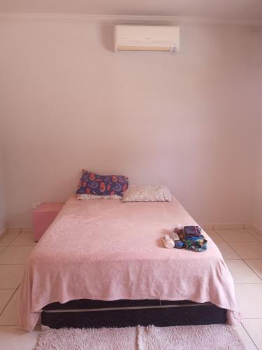 乌巴图巴Suite região central的卧室里设有粉红色的床,上面有一只动物