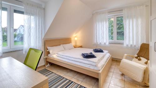 马克多夫Ferienwohnung Iris und Uwe的一间卧室配有一张床、一把椅子和窗户。