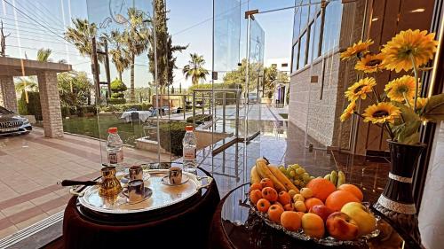 Ash Shumaysānīفندق الفاروق的玻璃桌,上面有水果和蔬菜