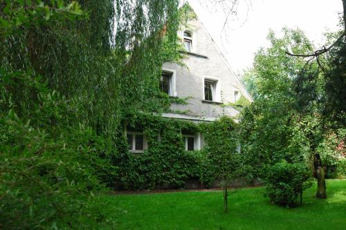 拉德库夫Noclegi nad Pośną的常春藤覆盖的建筑,有树木的院子