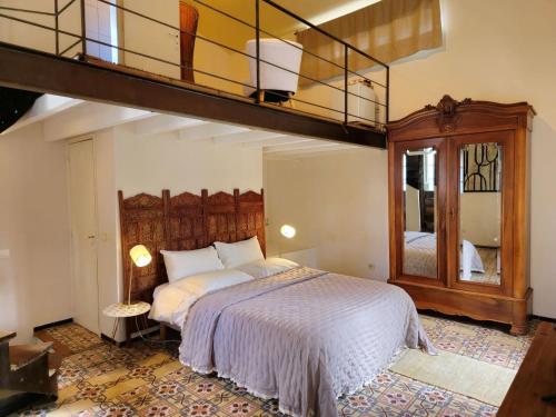 埃加利埃Ancien Mas Du Moulin的一间带一张大床的卧室和阁楼