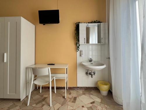 切萨诺博斯科内Hotel Parini的一间带水槽、桌子和镜子的浴室