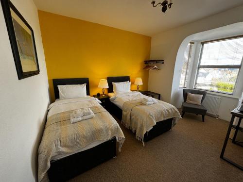 查尔德Watermead House的黄色墙壁客房的两张床