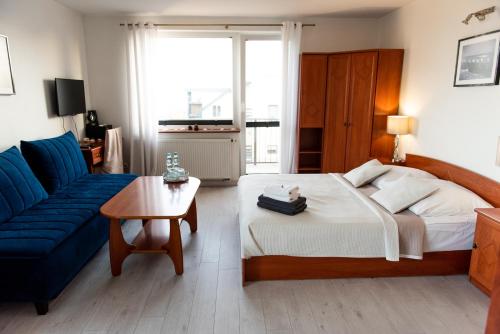 雷瓦Villa Plazowa 6的一间卧室配有一张大床和一张蓝色的沙发