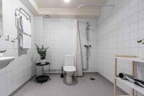 斯德哥尔摩Stylish Studio Haven Ideal for Four Guests的白色的浴室设有卫生间和淋浴。