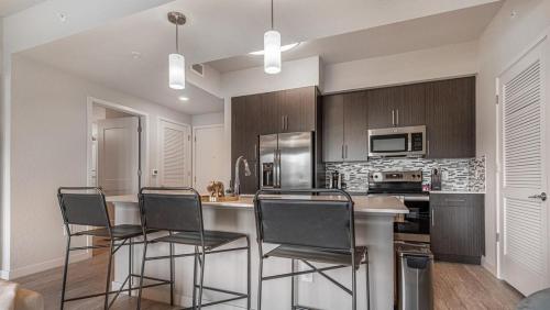 Fort Myers VillasLanding Modern Apartment with Amazing Amenities (ID8083X55)的厨房配有桌椅和冰箱。