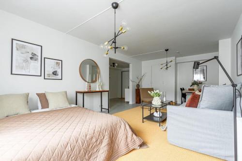 斯德哥尔摩Modern Charm Stylish Studio in Sodermalm的一间卧室设有一张床和一间客厅。