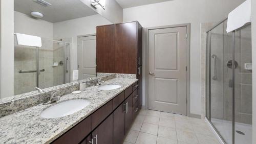 奥兰多Landing Modern Apartment with Amazing Amenities (ID9660X22)的一间带两个盥洗盆和淋浴的浴室