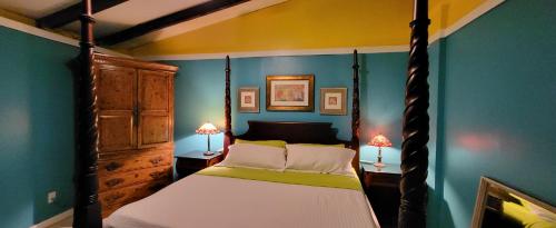 拿撒勒Tillett Gardens Guest House & Hostel的一间卧室配有四柱床和两盏灯。
