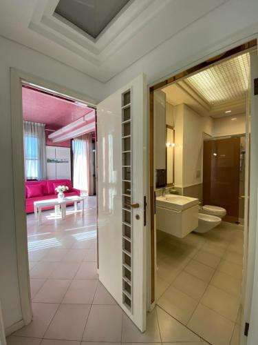 里乔内Villetta Trieste-Flexrent Abissinia的浴室设有一扇门,可通往带浴缸的浴室