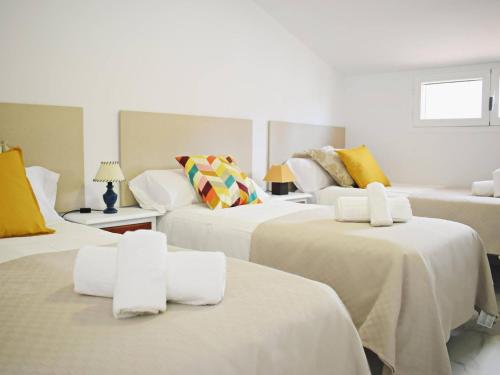托雷德尔马尔Espléndido chalet cerca de playa con piscina的酒店客房,配有3张带白色床单的床