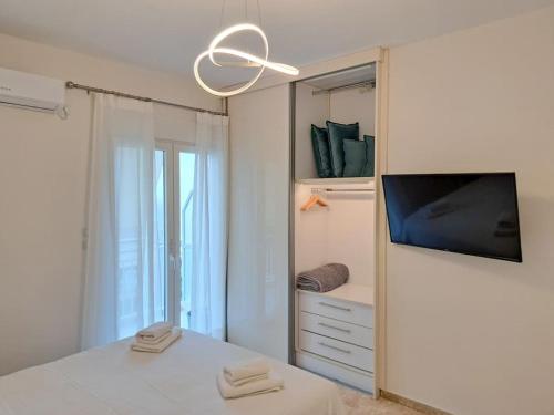 帕特雷Luxury Suite Patras (2)的一间白色卧室,配有电视和镜子