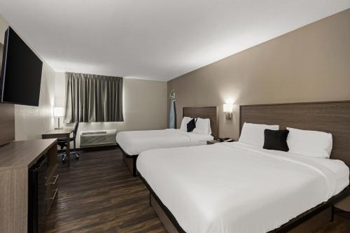 CaseyvilleRed Lion Inn & Suites Caseyville的酒店客房配有两张床和一张书桌