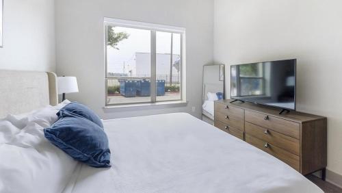 普莱诺Landing - Modern Apartment with Amazing Amenities (ID5020X49)的一间卧室设有一张床、一台电视和一个窗口。