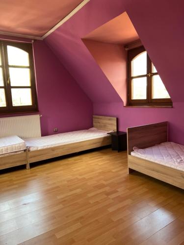 布达佩斯BRC Hostel & Car Rent Budapest的阁楼间设有两张床和紫色墙壁