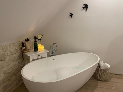 BouaflesL'histoire d'une hirondelle的浴室内设有大型白色浴缸。