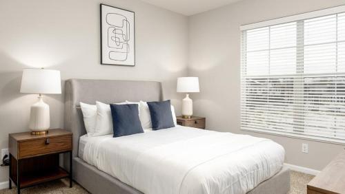 都柏林Landing - Modern Apartment with Amazing Amenities (ID8701X65)的一间卧室配有一张带蓝色枕头的床和一扇窗户。