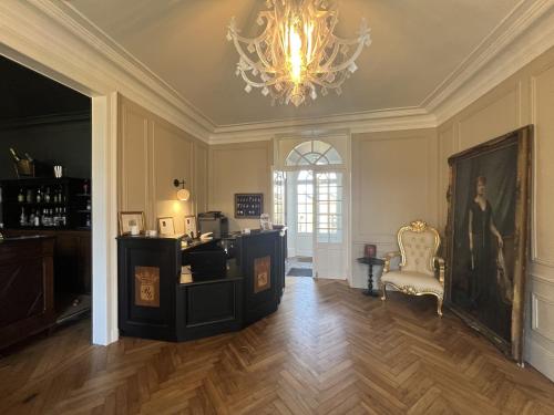 BonnevalHôtel du Château du Bois-Guibert的配有吊灯、书桌和椅子的客房
