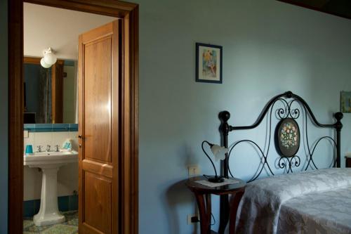 切雷托圭迪Agriturismo La Colombaia的一间卧室配有床、水槽和镜子