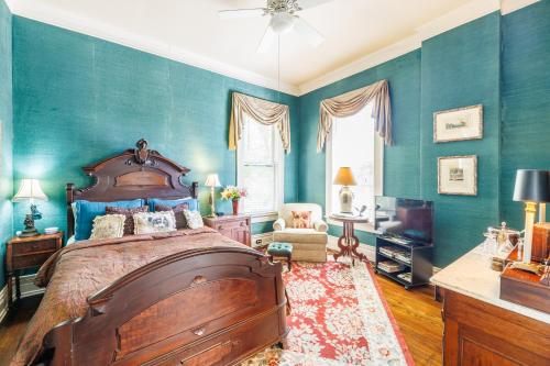 GonzalesBelle Oaks Inn的一间卧室设有一张大床和蓝色的墙壁