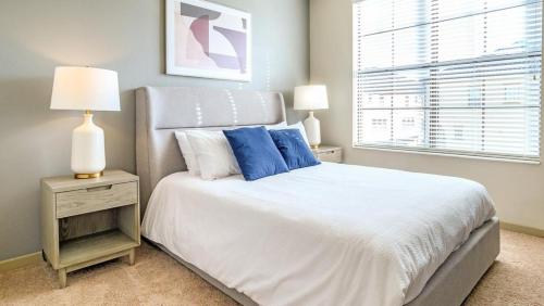 奥兰多Landing - Modern Apartment with Amazing Amenities (ID8201X11)的一间卧室配有一张带蓝色枕头的床和一扇窗户。
