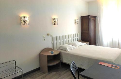 土伦新酒店的酒店客房配有一张床铺和一张桌子。
