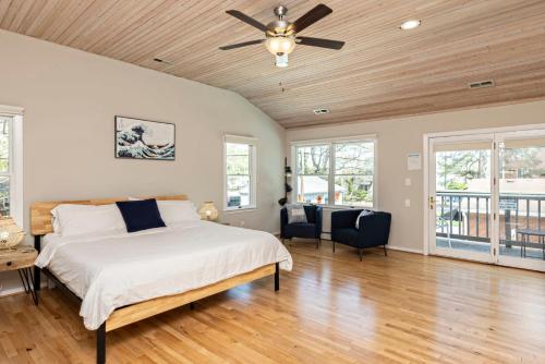 弗吉尼亚海滩The VIBE House with POOL的一间卧室配有一张床和吊扇