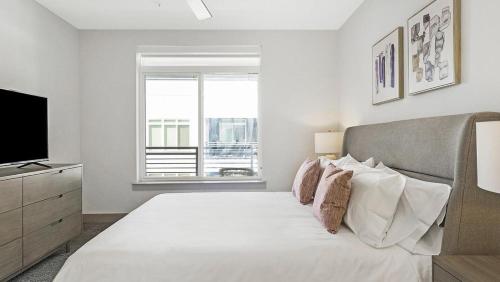 圣安东尼奥Landing - Modern Apartment with Amazing Amenities (ID9880X69)的一间白色卧室,配有床和电视