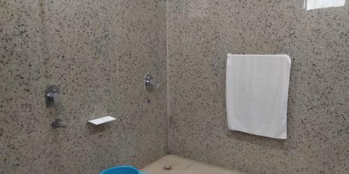 克久拉霍Hotel Radha Rani Mahal的带淋浴和白色毛巾的浴室
