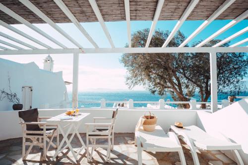 图罗斯With-inn Mykonos Suites的一个带白色桌椅的海景庭院