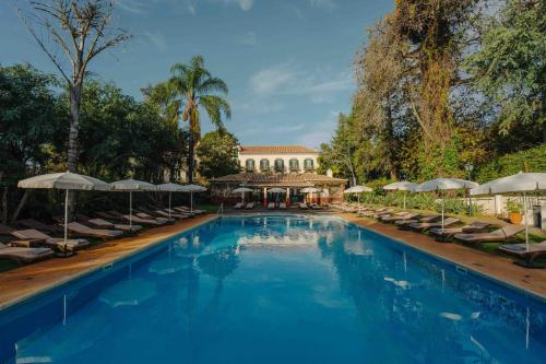 丰沙尔金塔达贝拉维斯塔酒店的一个带躺椅和遮阳伞的大型游泳池