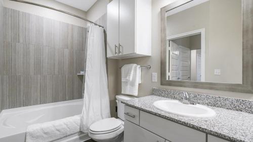 圣安东尼奥Landing - Modern Apartment with Amazing Amenities (ID8830X56)的白色的浴室设有水槽、卫生间和浴缸。
