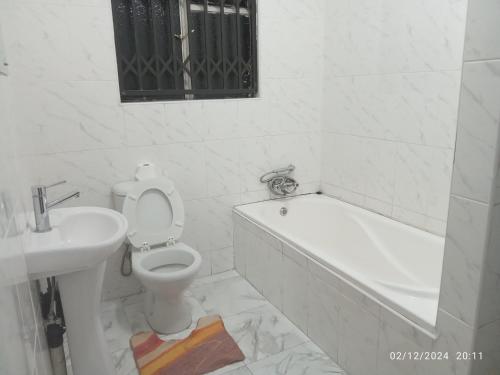 哈拉雷PaTerrace guest lodge的白色的浴室设有卫生间和水槽。
