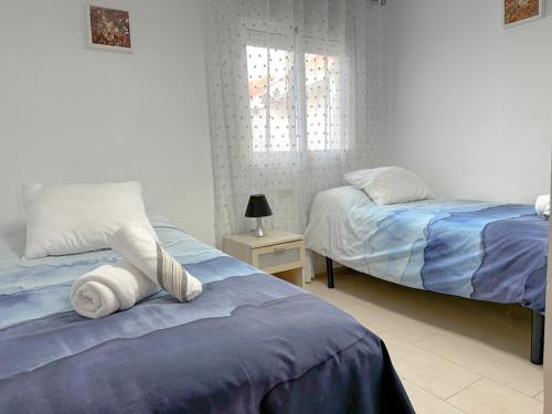 马拉加Apartamento Mirador del Mediterráneo的一间卧室设有两张床和窗户。