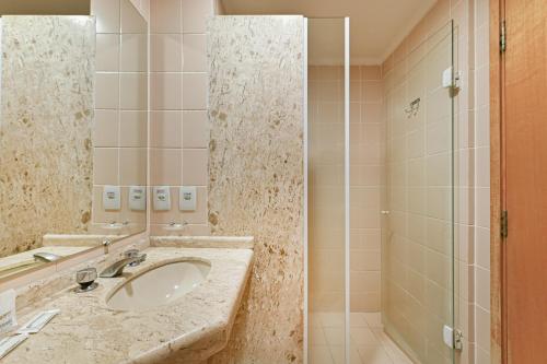 坎皮纳斯Hotel Golden Park Campinas Viracopos的一间带水槽和淋浴的浴室