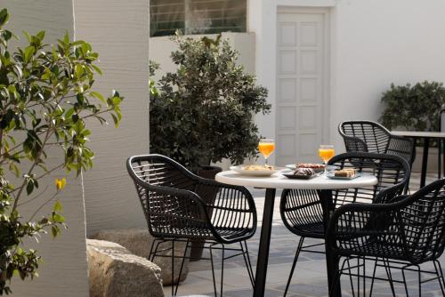 圣安娜纳克索斯伊里亚海滩艺术酒店的庭院里的桌椅和饮料
