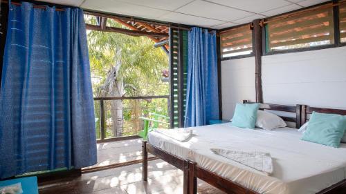 南圣胡安Playa Hermosa Eco Resort的一间卧室设有一张床和一个大窗户