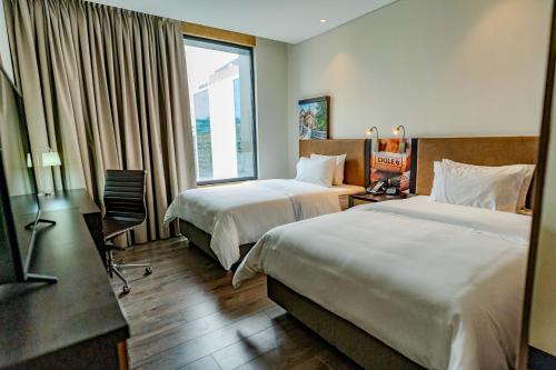 圣地亚哥Hampton By Hilton Santiago Las Condes的酒店客房设有两张床和窗户。