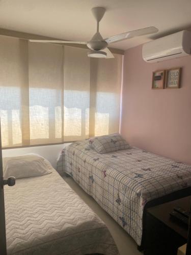 巴兰基亚Apartamento norte Barranquilla 2 habitaciones的一间卧室配有两张床和吊扇