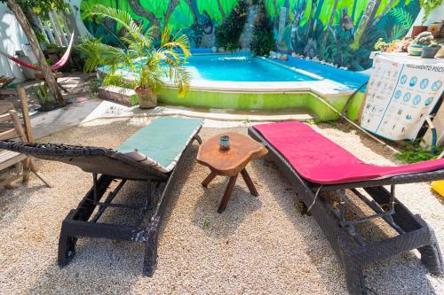 巴卡拉尔Zayali Bacalar - Guest House的一组椅子、一张桌子和一个游泳池