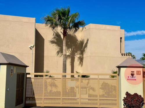 厄尔梅达诺Sol & Mar的一座棕榈树环绕在围栏后面的建筑