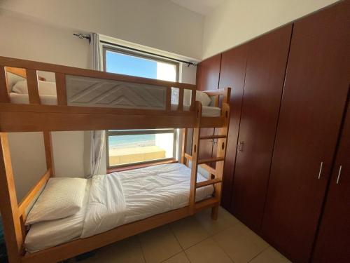 迪拜Sea View Beach Hostel - Walk to Beach - Metro Station - Pool的双层床间 - 带两张双层床和一扇窗户