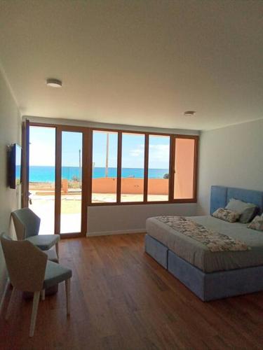 圣港Praia Encantada的一间卧室配有一张床,享有海景