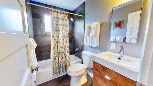摩押Downtown Cozy Home Base - Purple Sage 4的浴室配有卫生间、盥洗盆和淋浴。