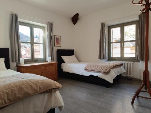 阿洛格诺Locanda La Pignatta的一间卧室设有两张床和两个窗户。