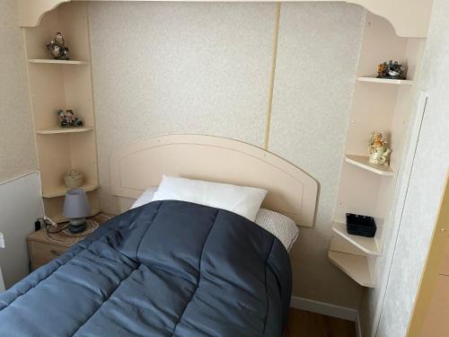 斯塔沃洛La caravane de Maminou的小卧室配有一张带蓝色枕头的床