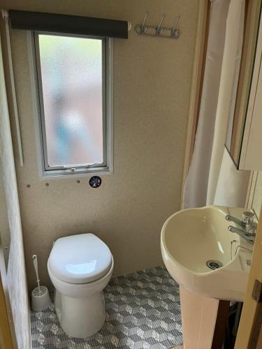 斯塔沃洛La caravane de Maminou的一间带卫生间、水槽和窗户的浴室